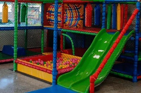 Brinquedão com escorregador verde e piscina de bolinhas instalado pela Só Brincadeiras